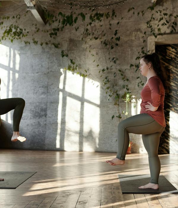 Person stretching peacefully in a bright, sunlit room.